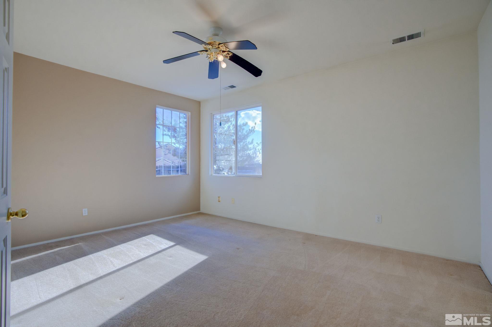 10692 Copper Moon Court Reno, NV 89521 - Photo 26 of 40 en empty room with windows and ceiling fan