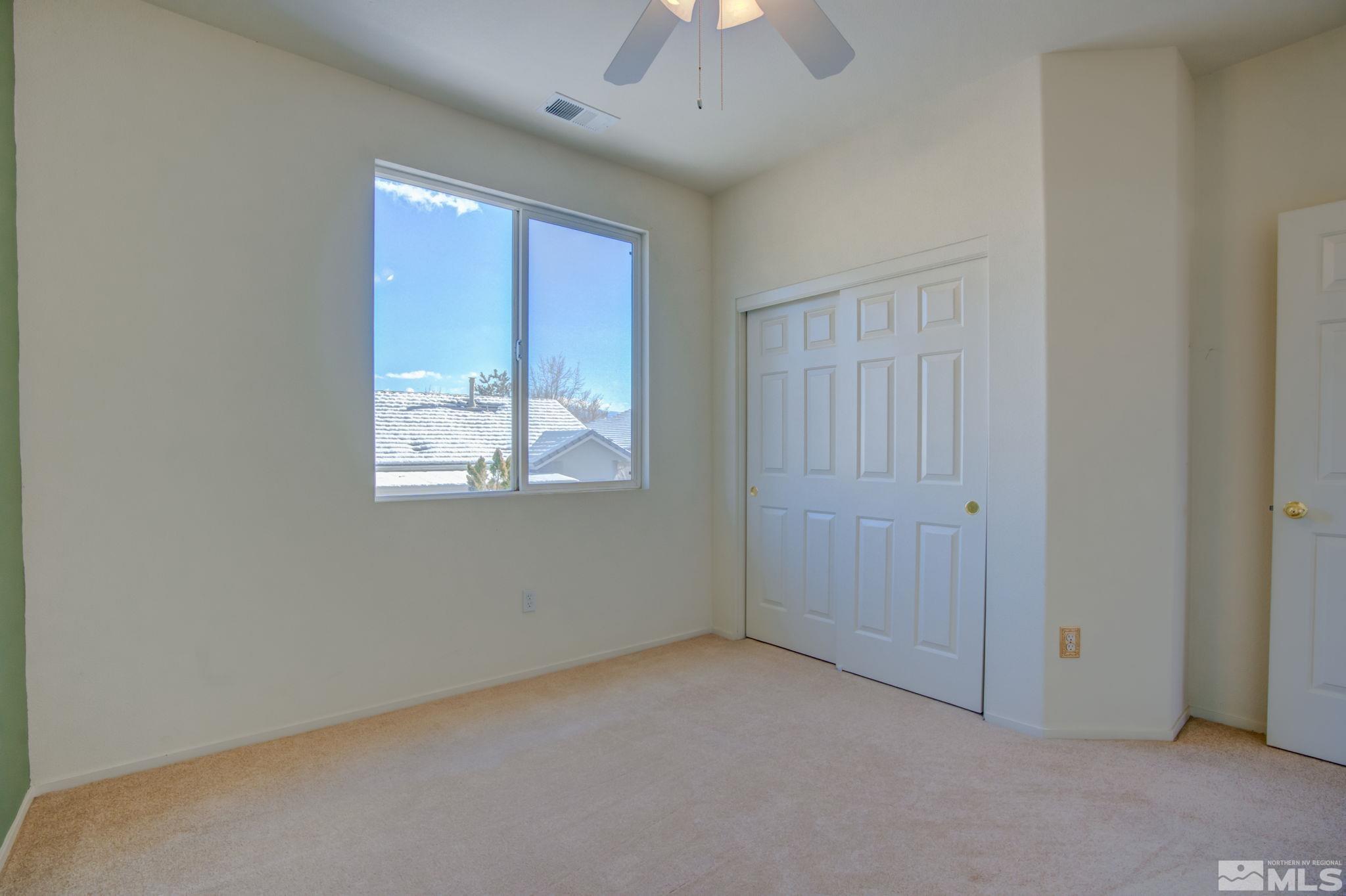 10692 Copper Moon Court Reno, NV 89521 - Photo 33 of 40 an empty room with windows and chandelier fan