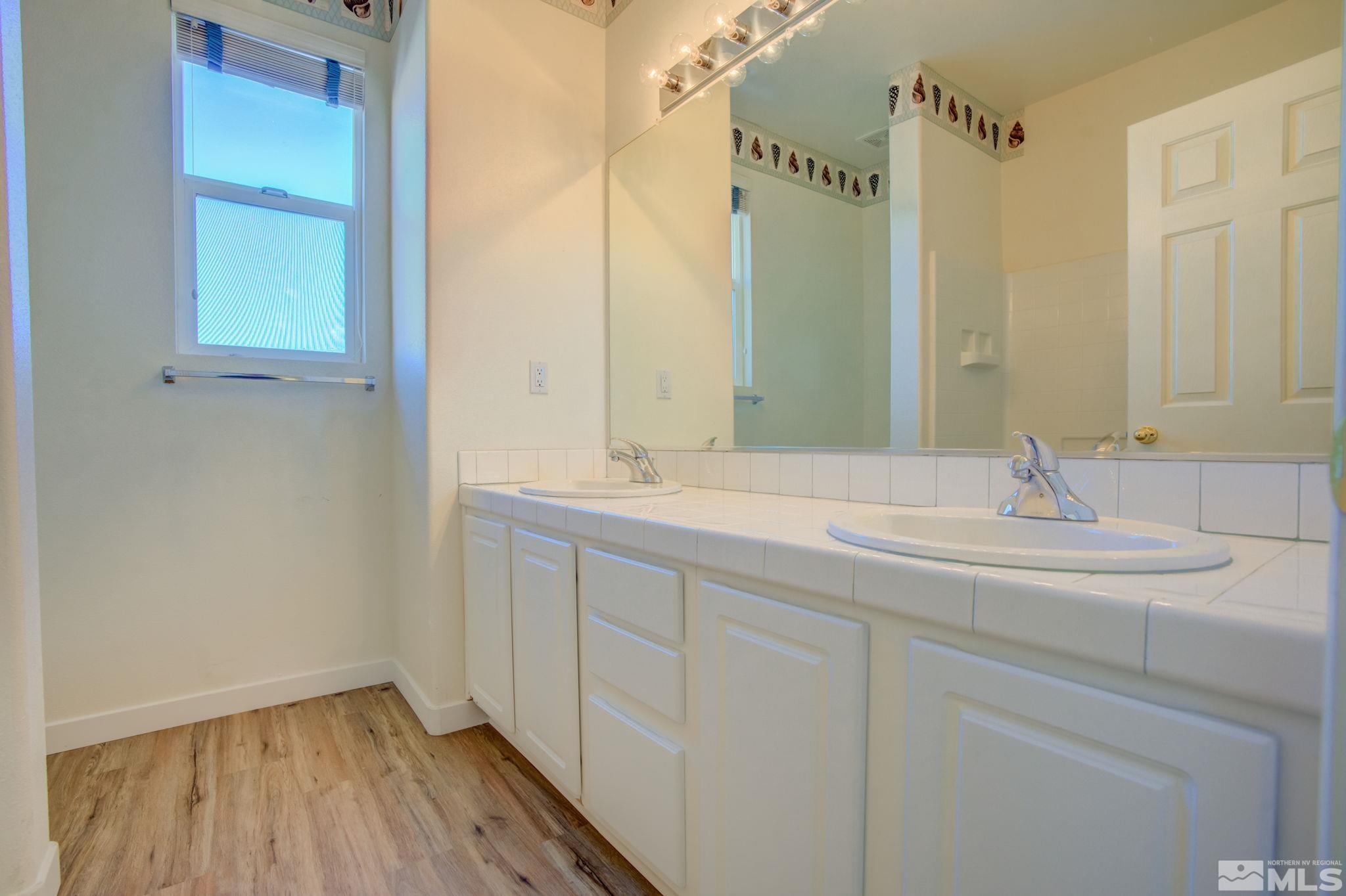 10692 Copper Moon Court Reno, NV 89521 - Photo 35 of 40 a bathroom with a double vanity sink and a mirror
