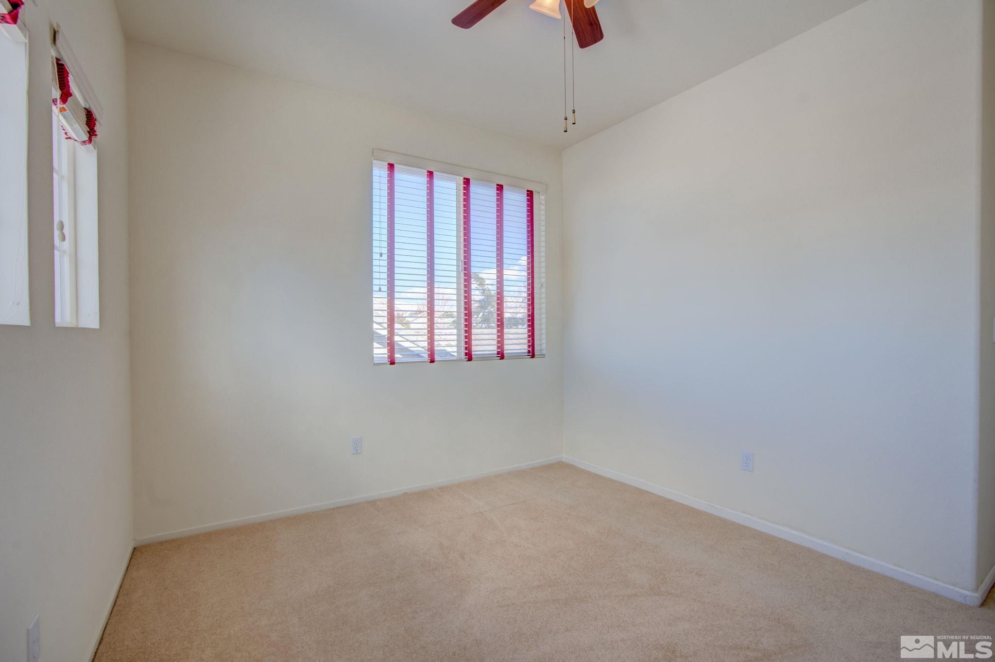 10692 Copper Moon Court Reno, NV 89521 - Photo 37 of 40 an empty room with a window and a ceiling fan