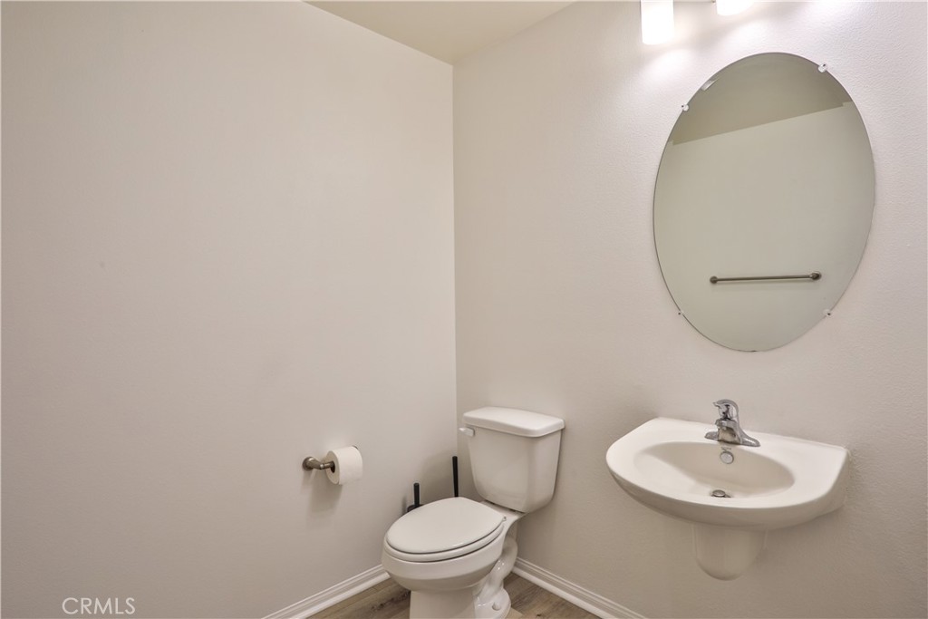 7863 Marbil Lane Riverside, CA 92504 - Photo 13 of 30 a bathroom with a toilet a sink and a mirror