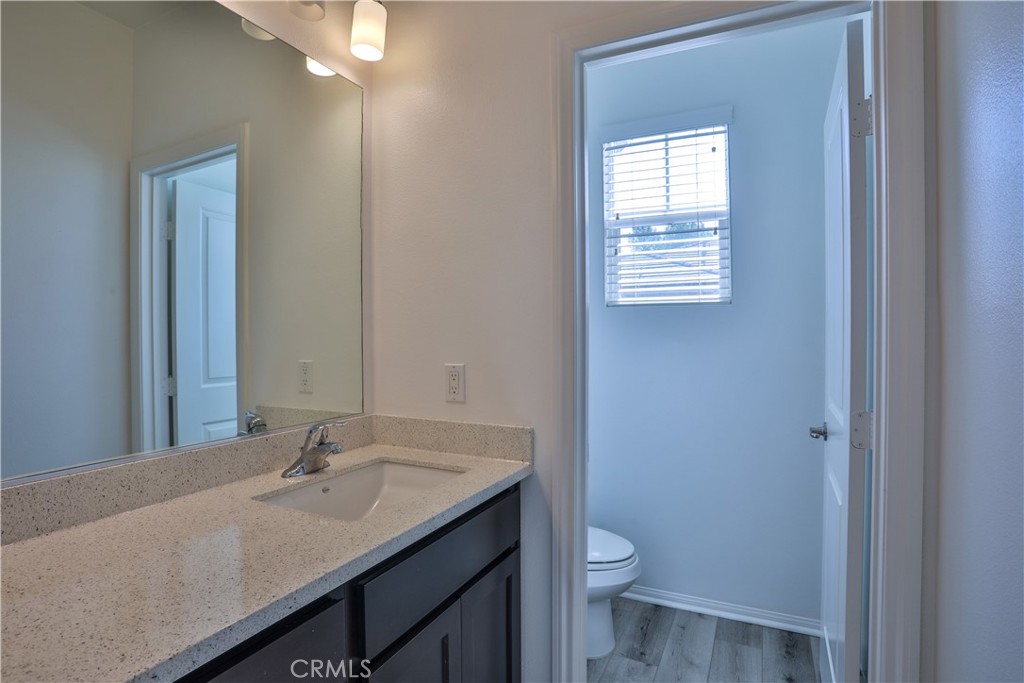 7863 Marbil Lane Riverside, CA 92504 - Photo 16 of 30 a bathroom with a granite countertop sink toilet and a mirror