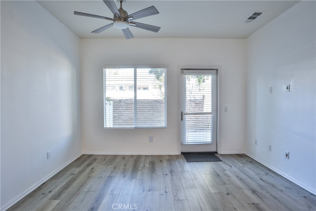 7863 Marbil Lane Riverside, CA 92504 - Photo 5 of 30 an empty room with wooden floor chandelier fan and windows