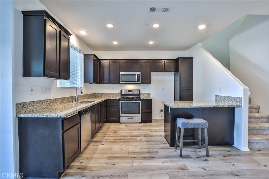 7863 Marbil Lane Riverside, CA 92504 - Photo 6 of 30 a large kitchen with stainless steel appliances granite countertop a stove and a refrigerator