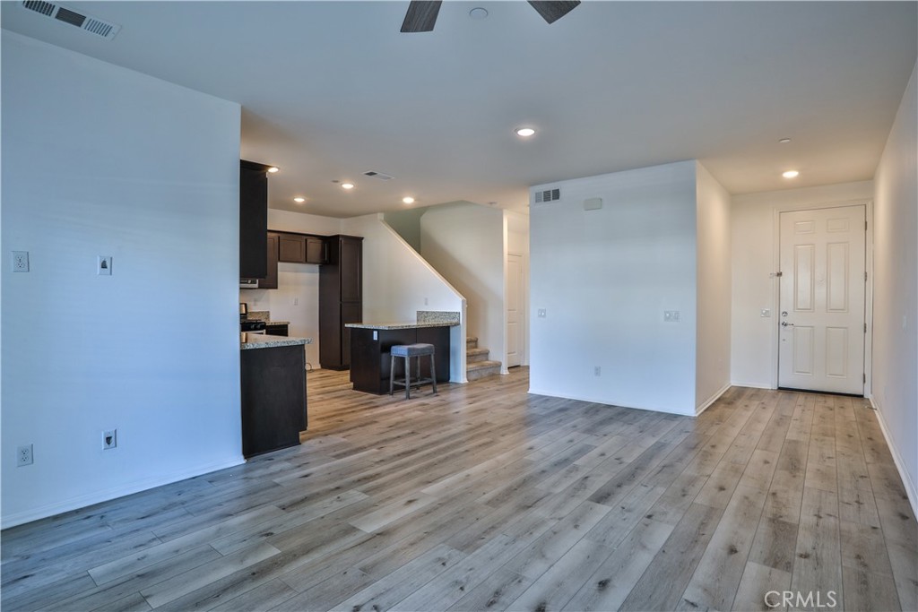 7863 Marbil Lane Riverside, CA 92504 - Photo 7 of 30 an empty room with wooden floor and fireplace