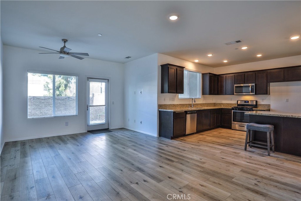 7863 Marbil Lane Riverside, CA 92504 - Photo 8 of 30 a large kitchen with kitchen island a island wooden cabinets and stainless steel appliances