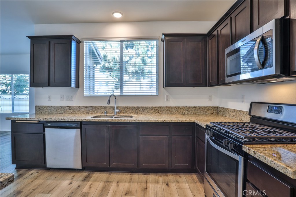 7863 Marbil Lane Riverside, CA 92504 - Photo 10 of 30 a kitchen with granite countertop a stove sink and cabinets