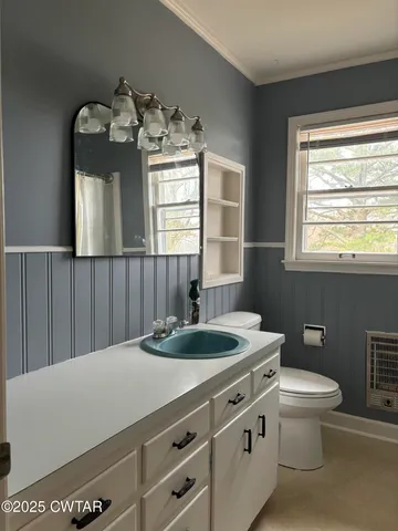 a bathroom with a granite countertop sink a toilet and mirror
