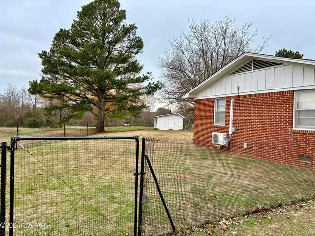a view of a backyard space with large trees