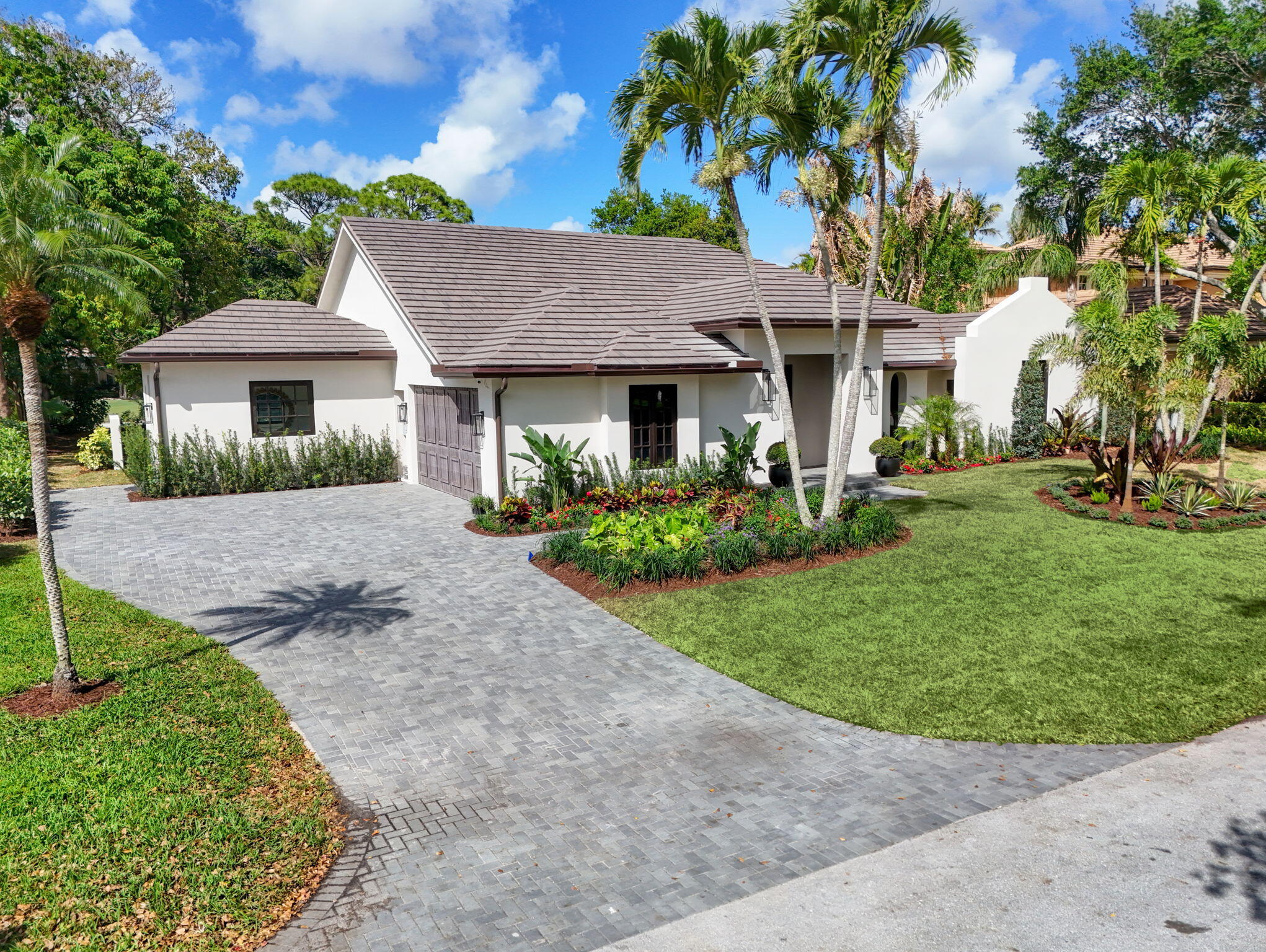 17 Carrick Road Palm Beach Gardens, FL 33418 - Photo 42 of 54 a front view of a house with a garden and yard