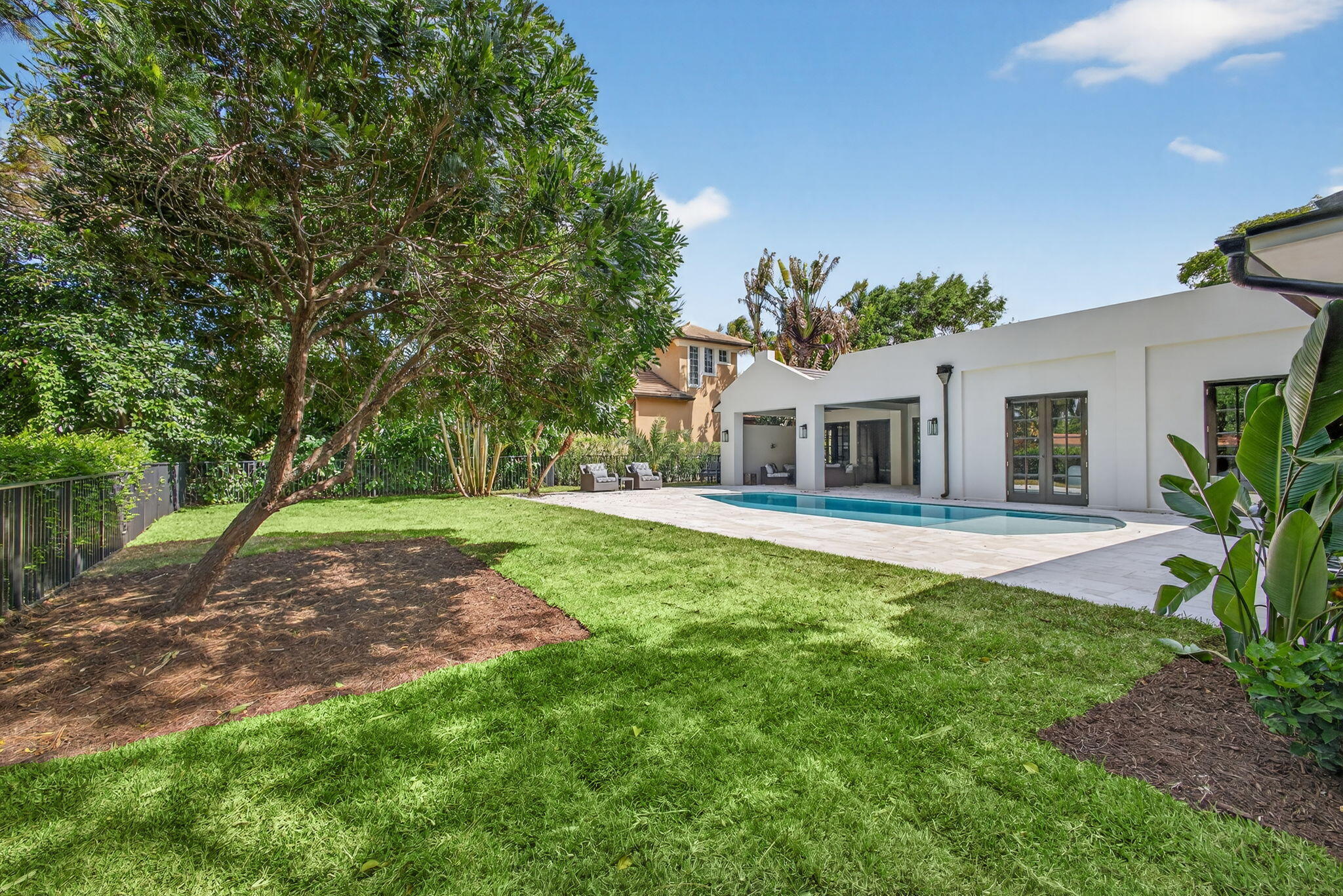 17 Carrick Road Palm Beach Gardens, FL 33418 - Photo 49 of 54 a white house with a big yard plants and large trees