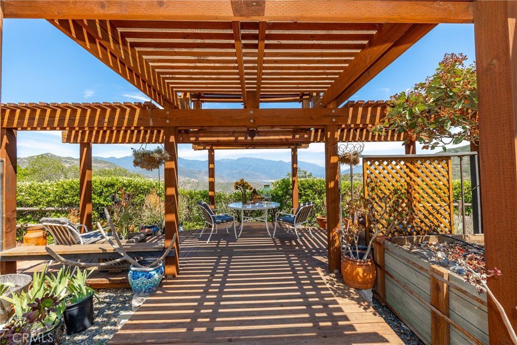 335 Rainbow Crest Road Fallbrook, CA 92028 - Photo 19 of 24 a view of a patio with lawn chairs barbeque oven and floor to ceiling window