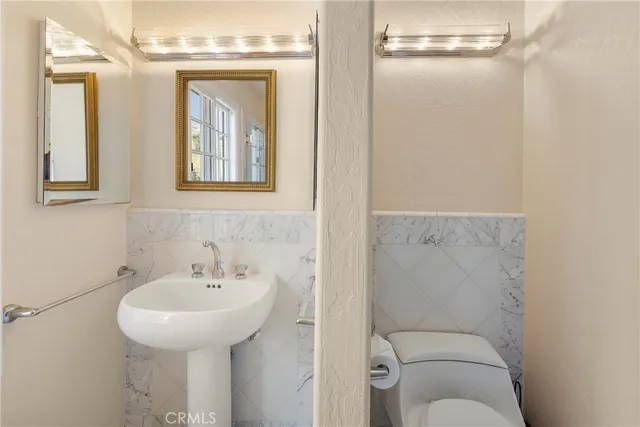 a bathroom with a toilet sink and mirror
