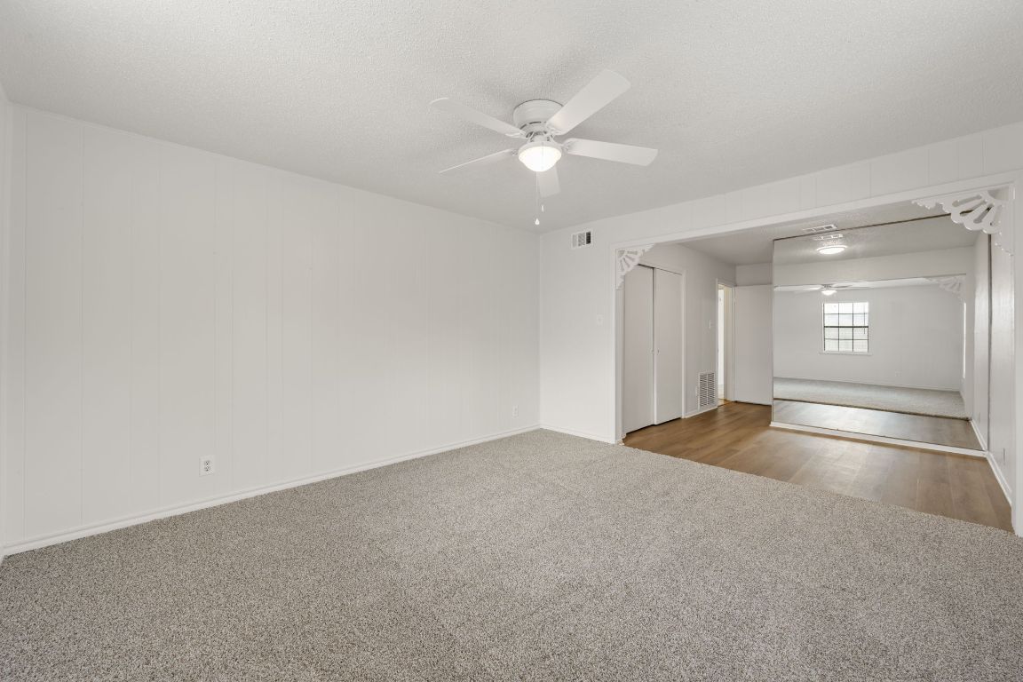 303 Irma Drive, Unit A Austin, TX 78752 - Photo 20 of 35 Spare room with ceiling fan, light carpet, and a textured ceiling