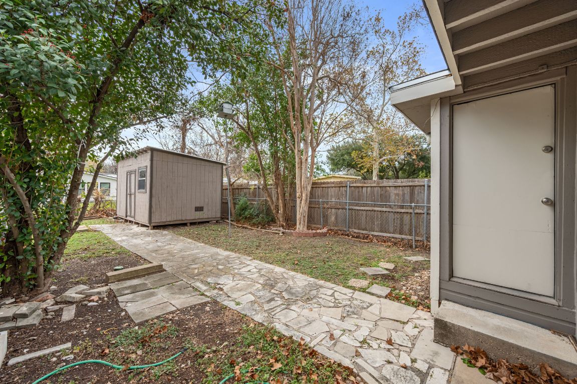 303 Irma Drive, Unit A Austin, TX 78752 - Photo 24 of 35 Fenced backyard with a storage unit