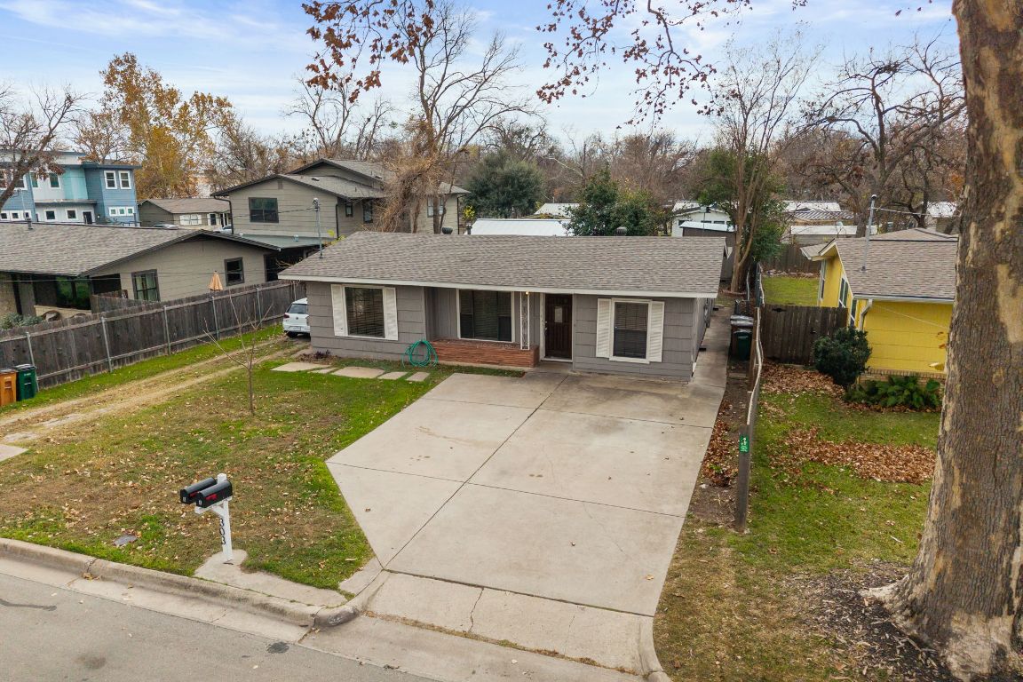 303 Irma Drive, Unit A Austin, TX 78752 - Photo 26 of 35 View of front of property featuring a residential view, roof with shingles, concrete driveway, and covered porch
