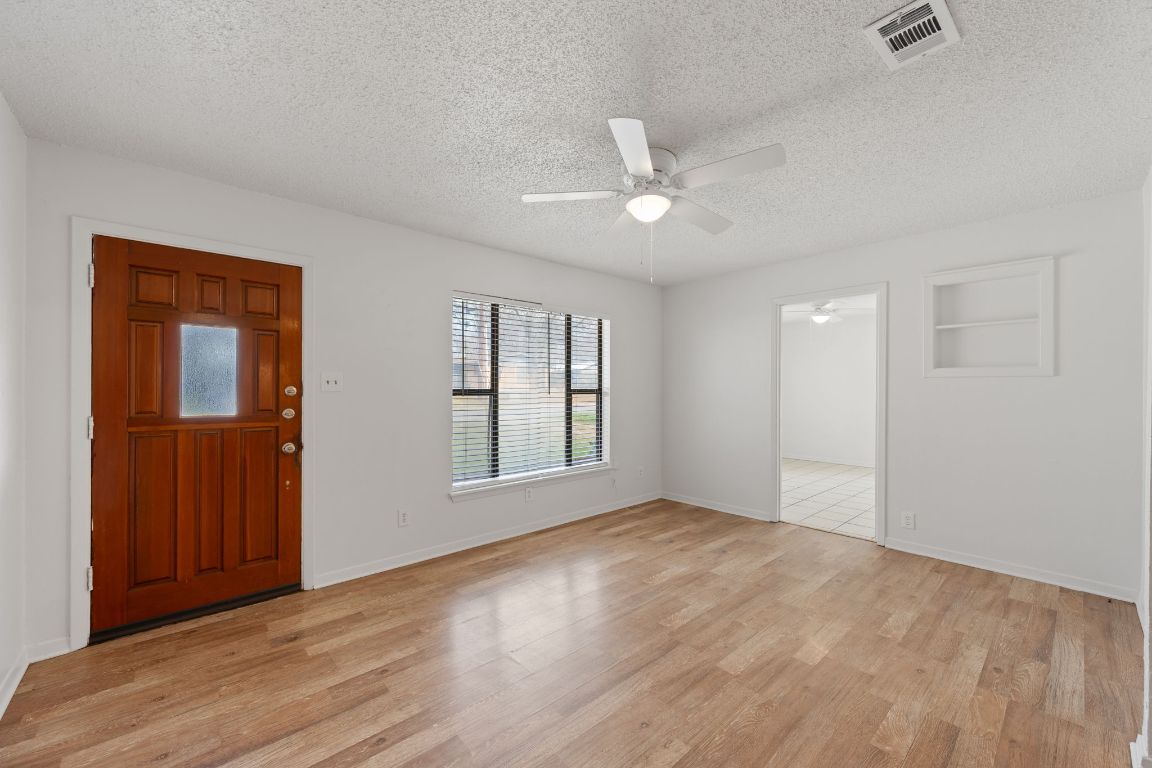 303 Irma Drive, Unit A Austin, TX 78752 - Photo 3 of 35 Foyer entrance with light wood-style flooring, a textured ceiling, and ceiling fan
