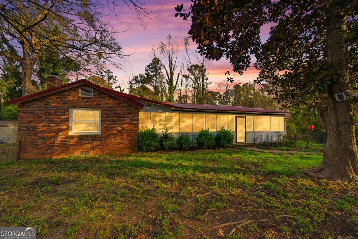 a view of a yard in front of a house with a large tree