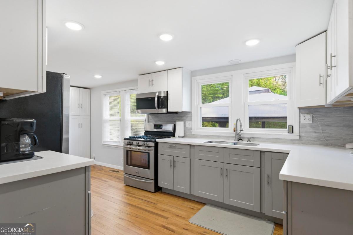 296 Kings Road Milledgeville, GA 31061 - Photo 15 of 36 a kitchen with a sink a stove a refrigerator and white cabinets