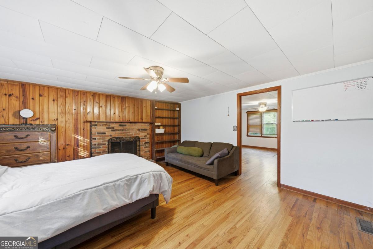 296 Kings Road Milledgeville, GA 31061 - Photo 27 of 36 a spacious bedroom with a bed a dresser and wooden floor