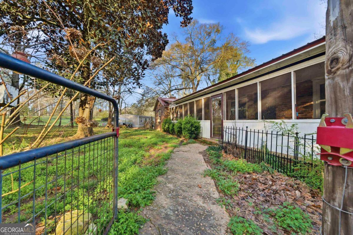 296 Kings Road Milledgeville, GA 31061 - Photo 4 of 36 a view of a house with a small yard and wooden fence