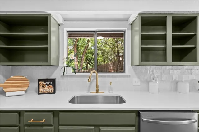 a sink with a window and cabinets