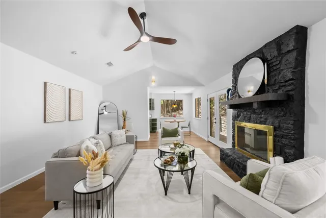 a living room with furniture a fireplace a rug and a window