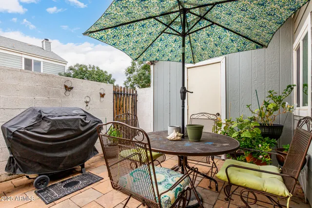 a view of a backyard with table and chairs under an umbrella