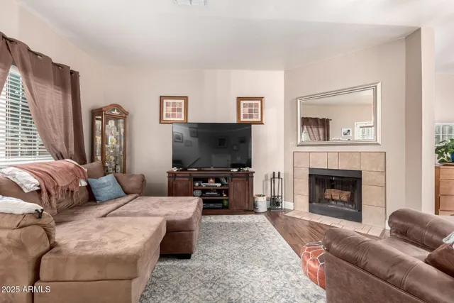 a living room with furniture a fireplace and a flat screen tv