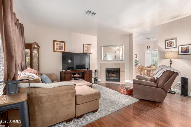a living room with furniture a flat screen tv and a fireplace