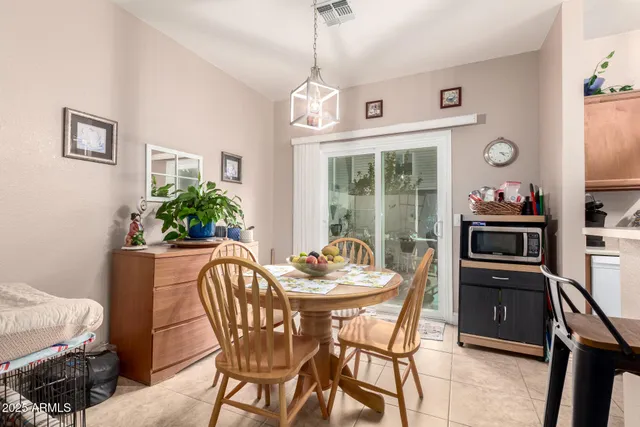 a dining room with furniture a chandelier and wooden floor