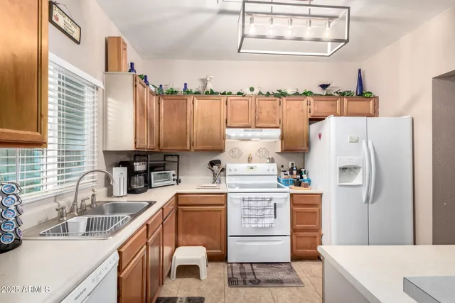 a kitchen with a refrigerator sink and white cabinets