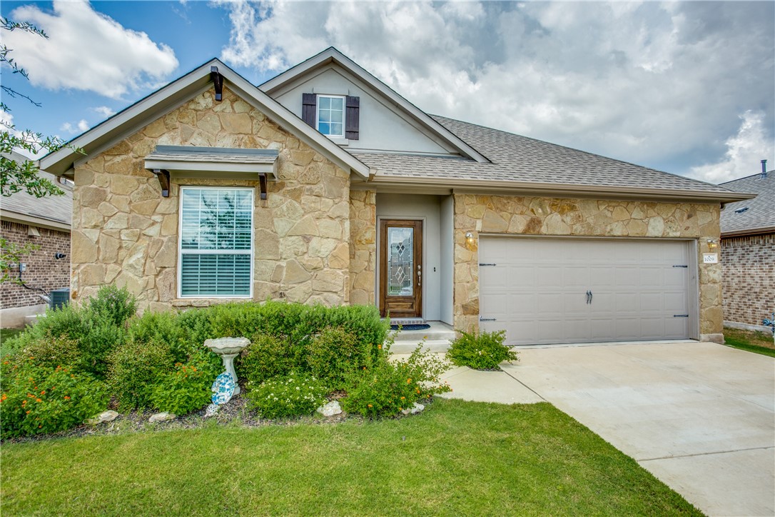 a front view of a house with a garden and yard