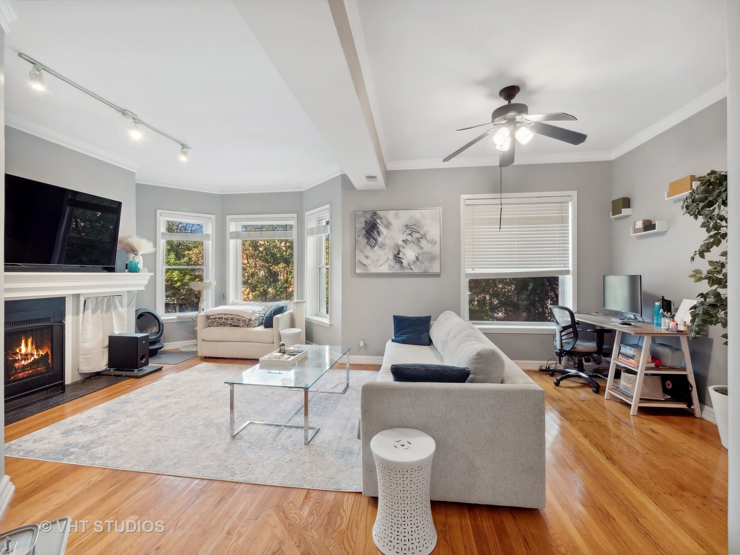 1023 West Dakin Street, Unit 2W Chicago, IL 60613 - Photo 2 of 10 a living room with furniture a fireplace and a flat screen tv