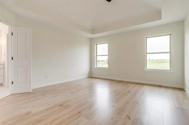 an empty room with wooden floor and window