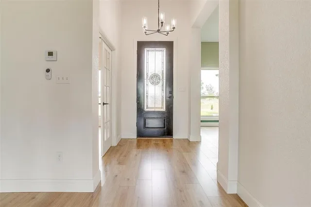 a view of a hallway with wooden floor and a bathroom