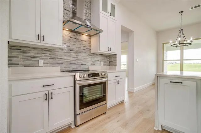 a kitchen with stainless steel appliances white cabinets and a stove