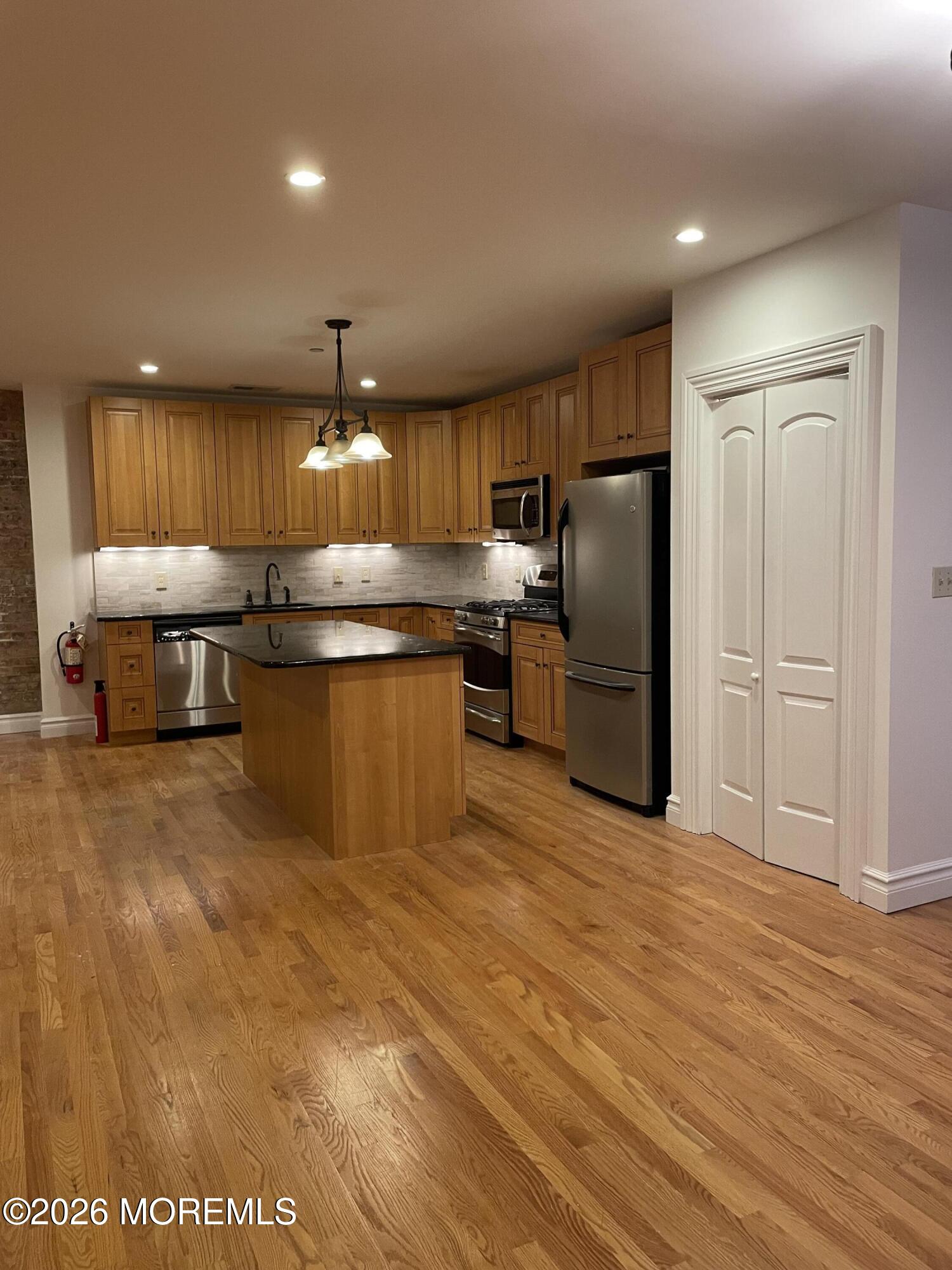 8 East Front Street, Unit 204 Red Bank, NJ 07701 - Photo 6 of 15 a kitchen with stainless steel appliances granite countertop a refrigerator and a stove top oven