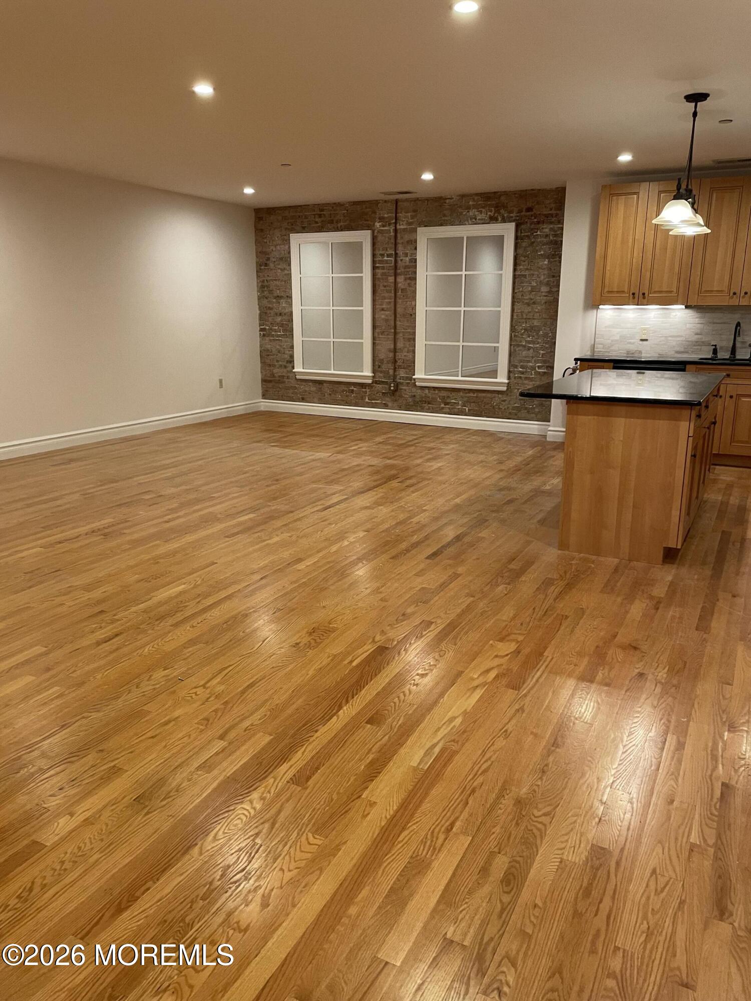 8 East Front Street, Unit 204 Red Bank, NJ 07701 - Photo 7 of 15 a view of a livingroom with wooden floor and a kitchen