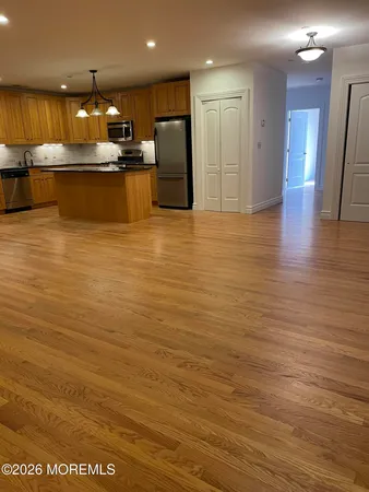 a large kitchen with stainless steel appliances wooden floors and granite counter tops