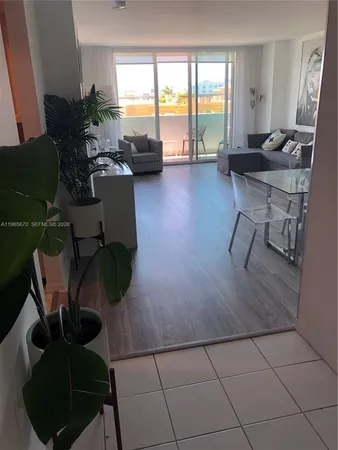 a living room with furniture floor to ceiling window and a table