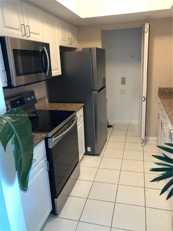 a kitchen with granite countertop a refrigerator and a stove