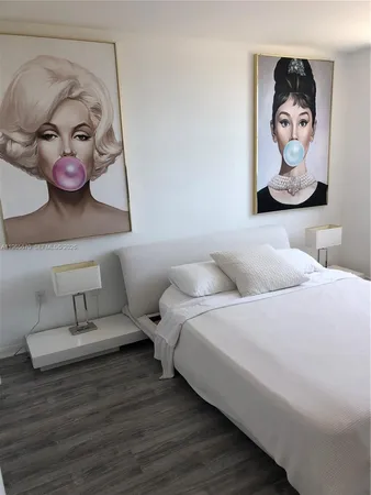 a bedroom with a bed and painting on the wall