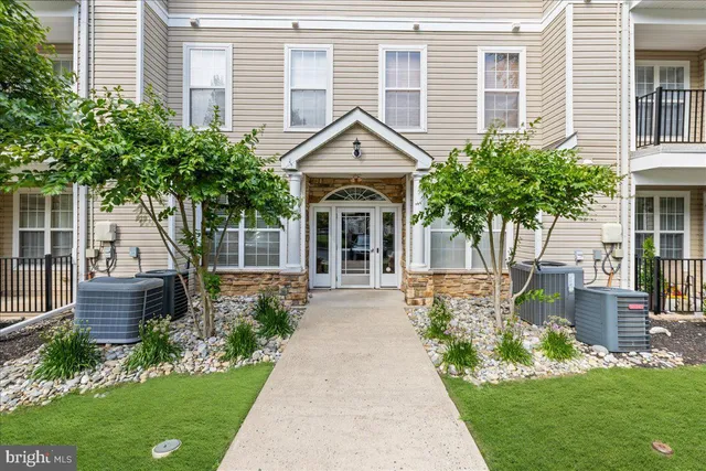 a front view of a house with a yard and potted plants