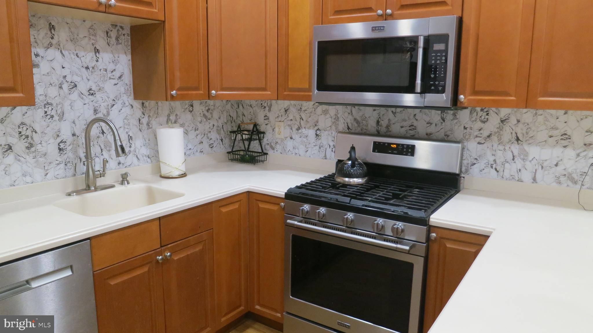 121 Kyle Way Ewing, NJ 08628 - Photo 9 of 25 a kitchen with granite countertop a stove top oven microwave and cabinets