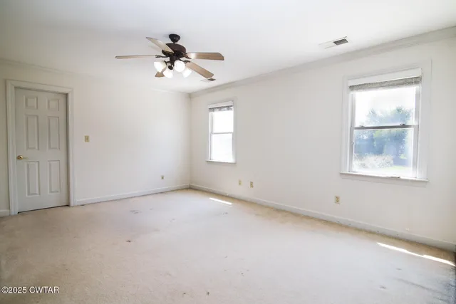 an empty room with a window and a ceiling fan
