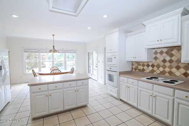 a kitchen with white cabinets and sink