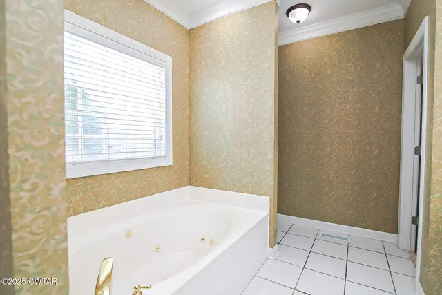 a white bath tub sitting in a bathroom next to a window