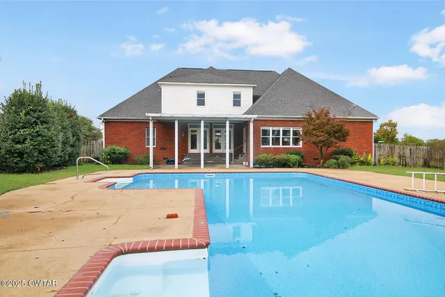 a view of house with swimming pool and porch