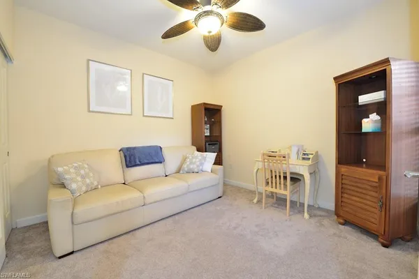 a living room with furniture and a ceiling fan